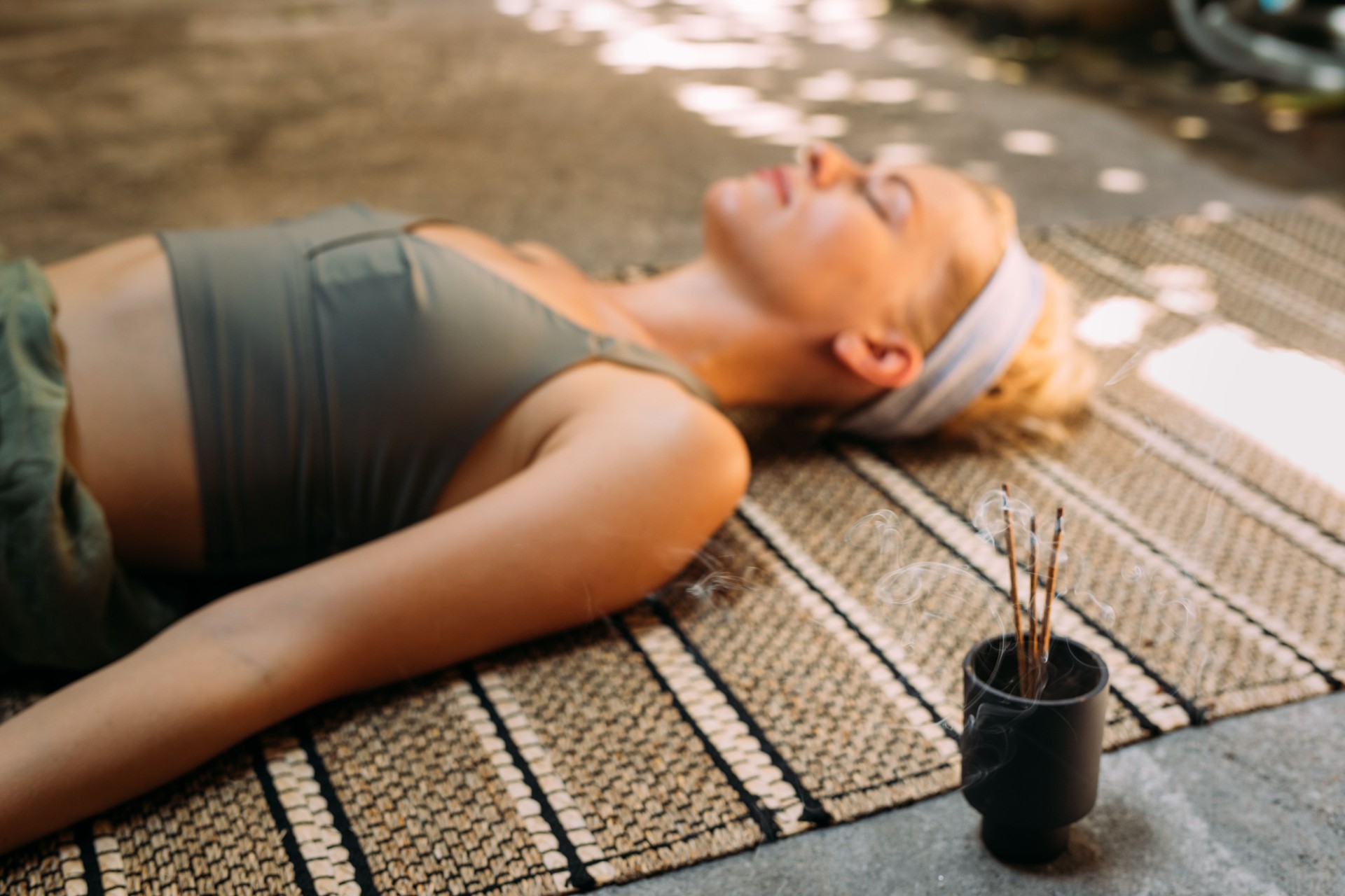 Woman Practicing Yoga with Incense Sticks beside her